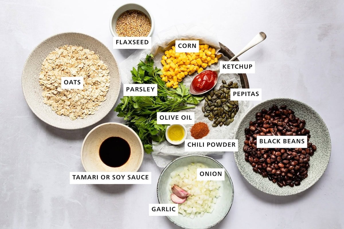 Ingredients to make black bean burgers with labels including beans, veggies, oats and spices.