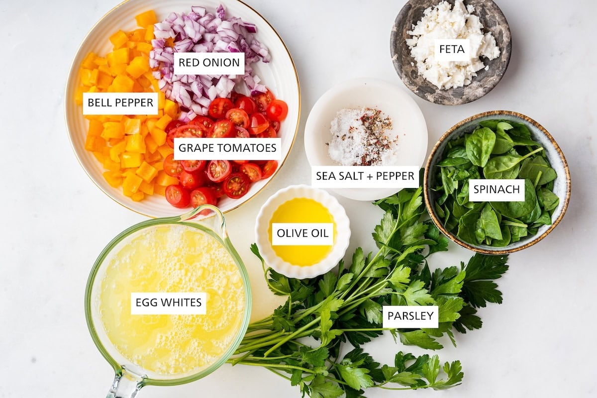 Ingredients measured out to make Egg White Frittata: egg whites, bell pepper, red onion, grape tomatoes, olive oil, sea salt, pepper, parsley, spinach and feta.