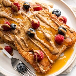 Protein French toast topped with peanut butter drizzle and fresh berries.
