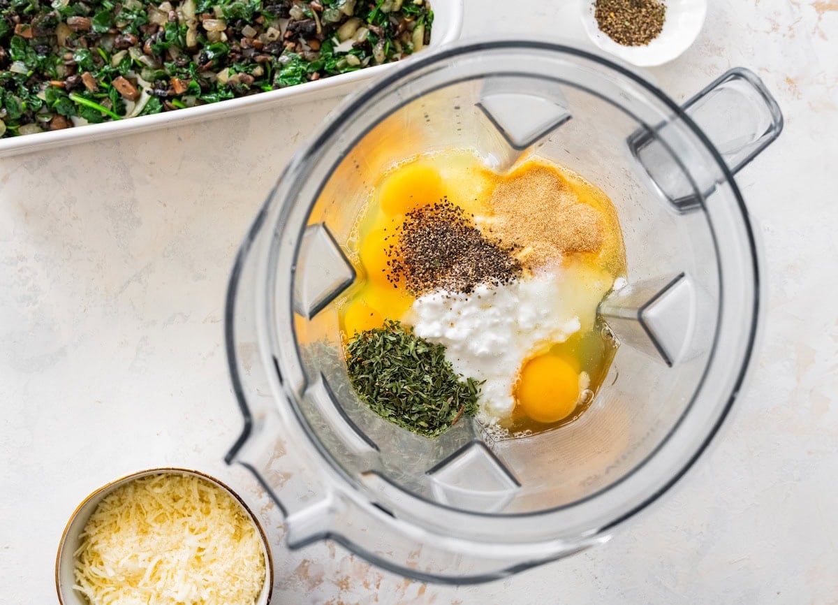 Eggs, cottage cheese, and seasonings in blender for baked cottage cheese eggs mixture.