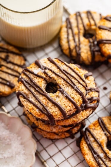 Multiple banana samoas cookies stacked on each other on a cooling rack.
