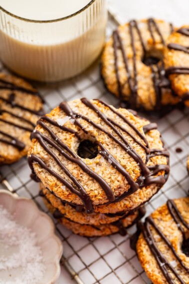 Multiple banana samoas cookies stacked on each other on a cooling rack.