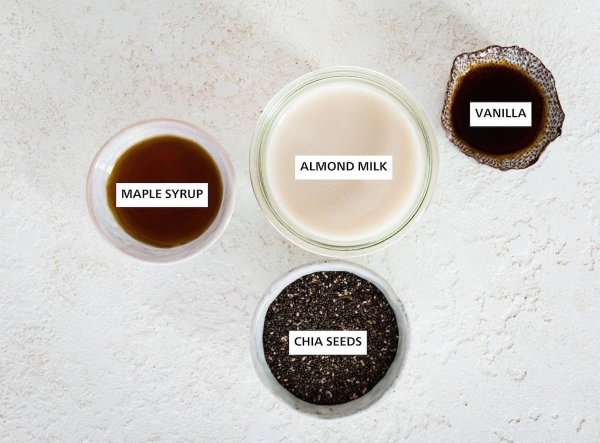Ingredients measured out to make chia seed pudding: maple syrup, chia seeds, almond milk and vanilla.