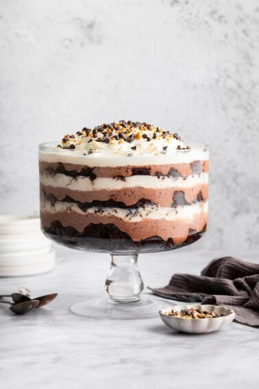 Assembled chocolate trifle showing layers of brownies, pudding, and whipped topping in a glass trifle dish.