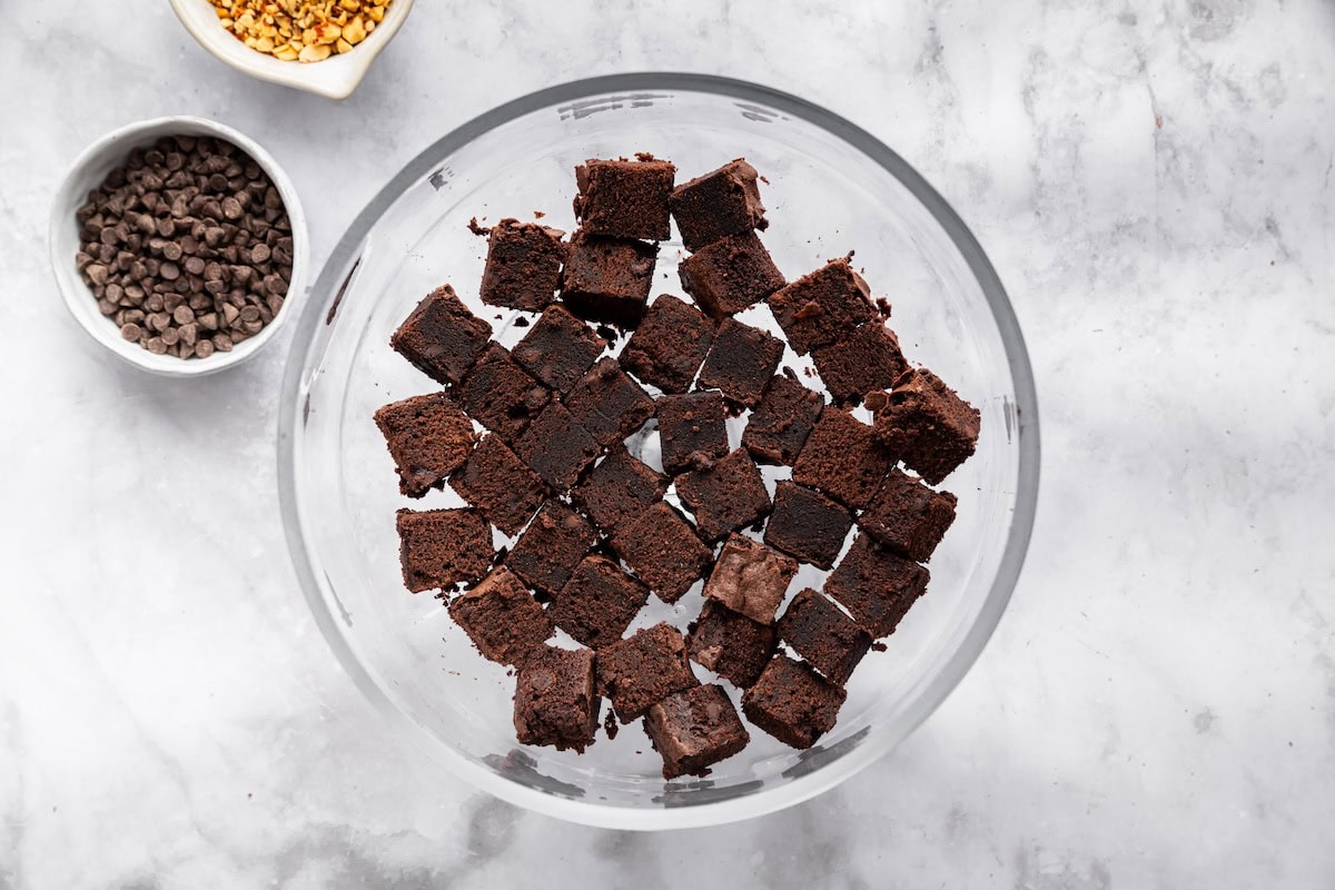 Cubed protein brownies arranged at the bottom of a trifle dish for the first layer.