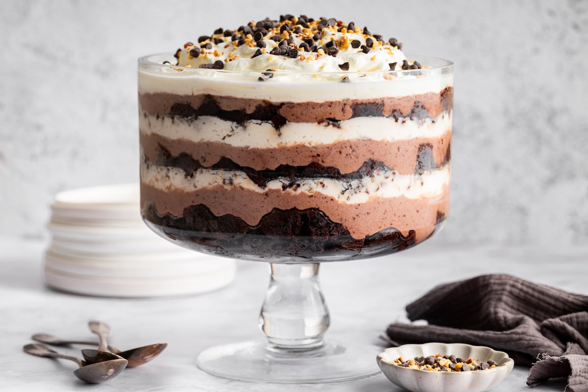 Assembled chocolate trifle showing layers of brownies, pudding, and whipped topping in a glass trifle dish.
