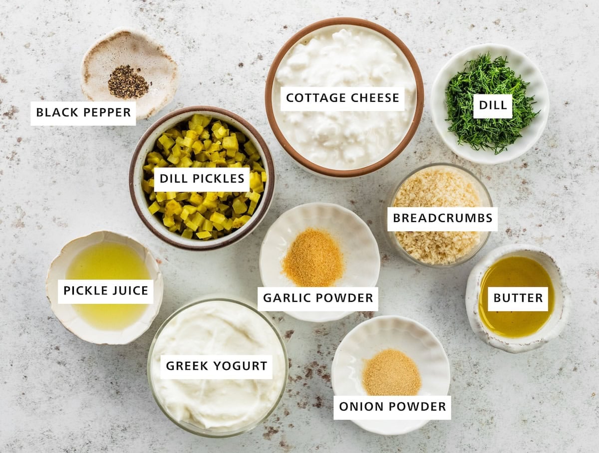 Ingredients measured for fried pickle dip: cottage cheese, dill pickles, black pepper, pickle juice, greek yogurt, garlic powder, onion powder, breadcrumbs, dill, and butter.
