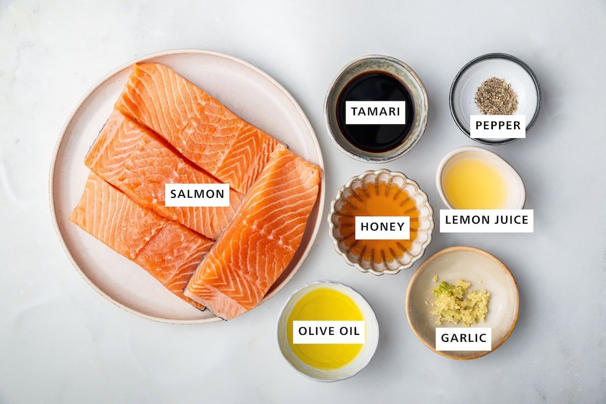 Ingredients measured out to make Honey Glazed Salmon: salmon, olive oil, honey, tamari, garlic, lemon juice and pepper.