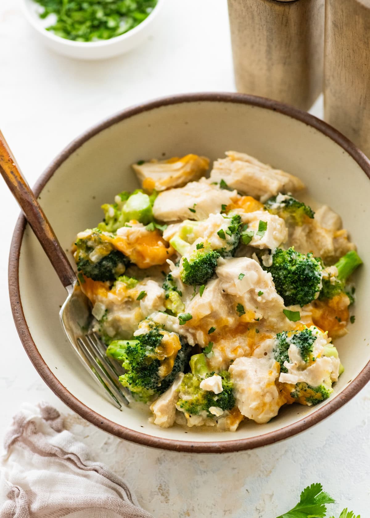 Slow cooker chicken and rice with broccoli and cheddar cheese in a bowl.