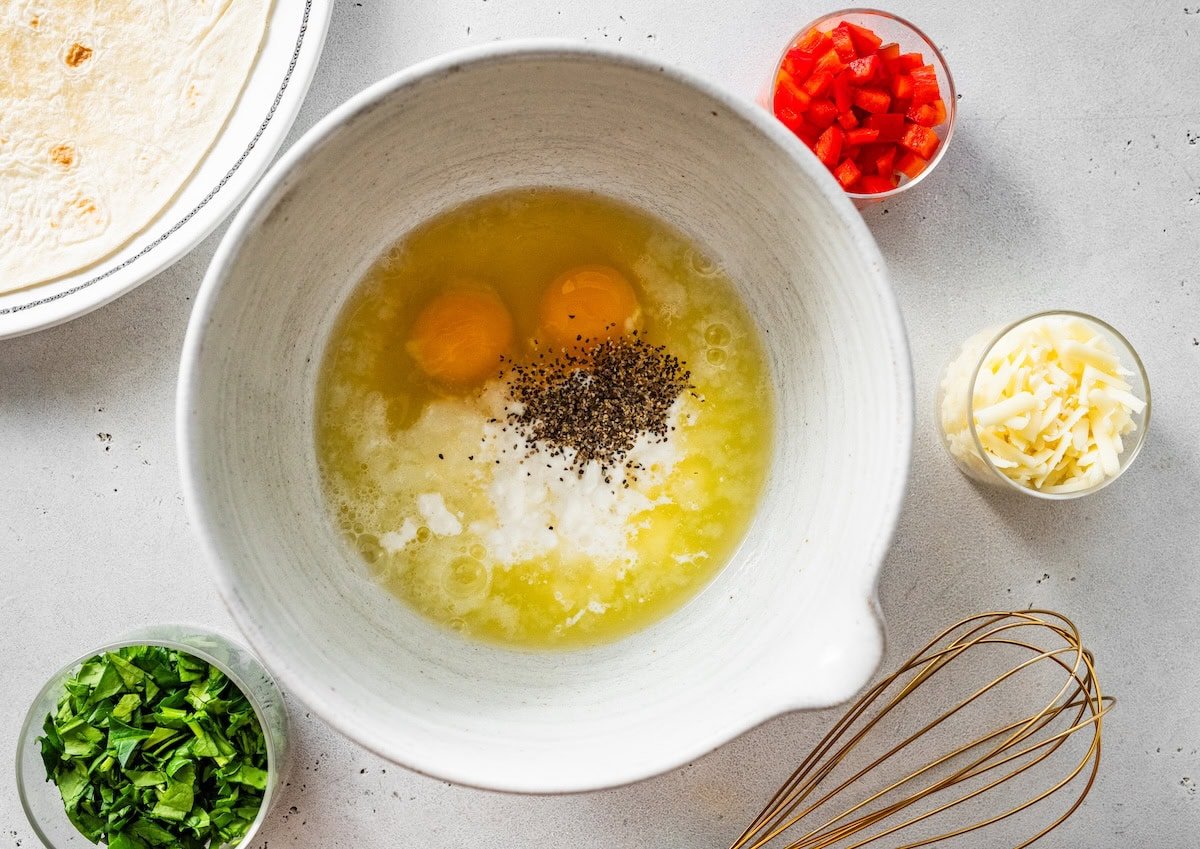 Eggs, egg whites, cottage cheese, and seasoning whisked together for tortilla quiche filling.