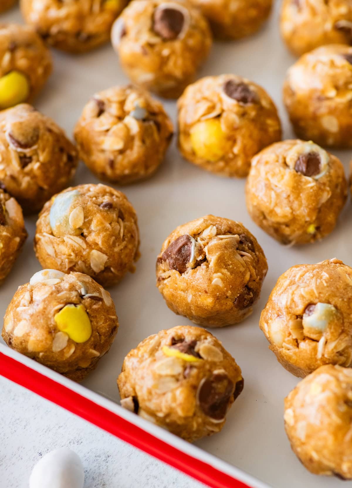 Cadbury egg protein balls spread out across a baking sheet.