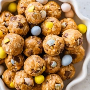 A bowl of protein balls with Cadbury Eggs around the balls in the bowl.