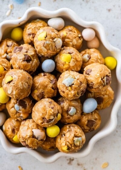 A bowl of protein balls with Cadbury Eggs around the balls in the bowl.