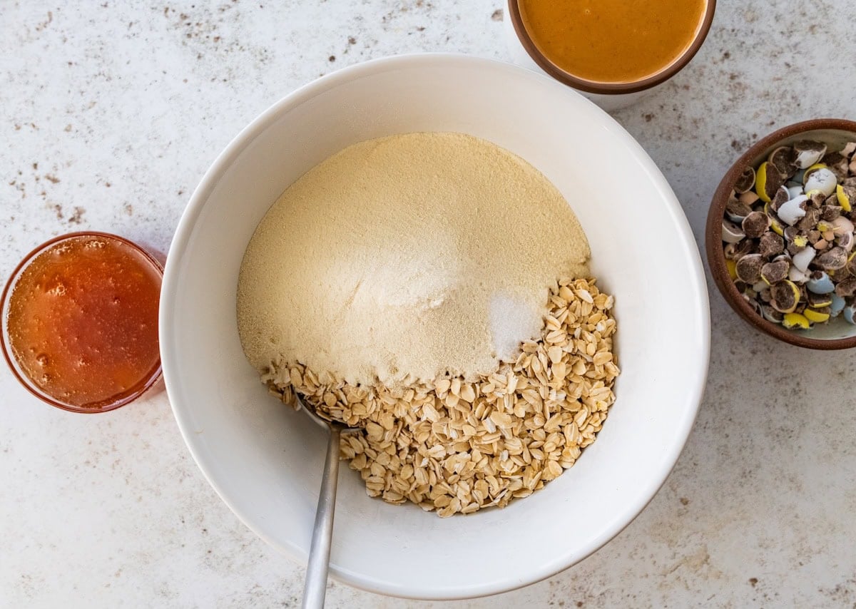 A large mixing bowl with quick oats and protein powder.