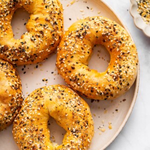 Close up of golden cottage cheese bagels topped with everything seasoning.