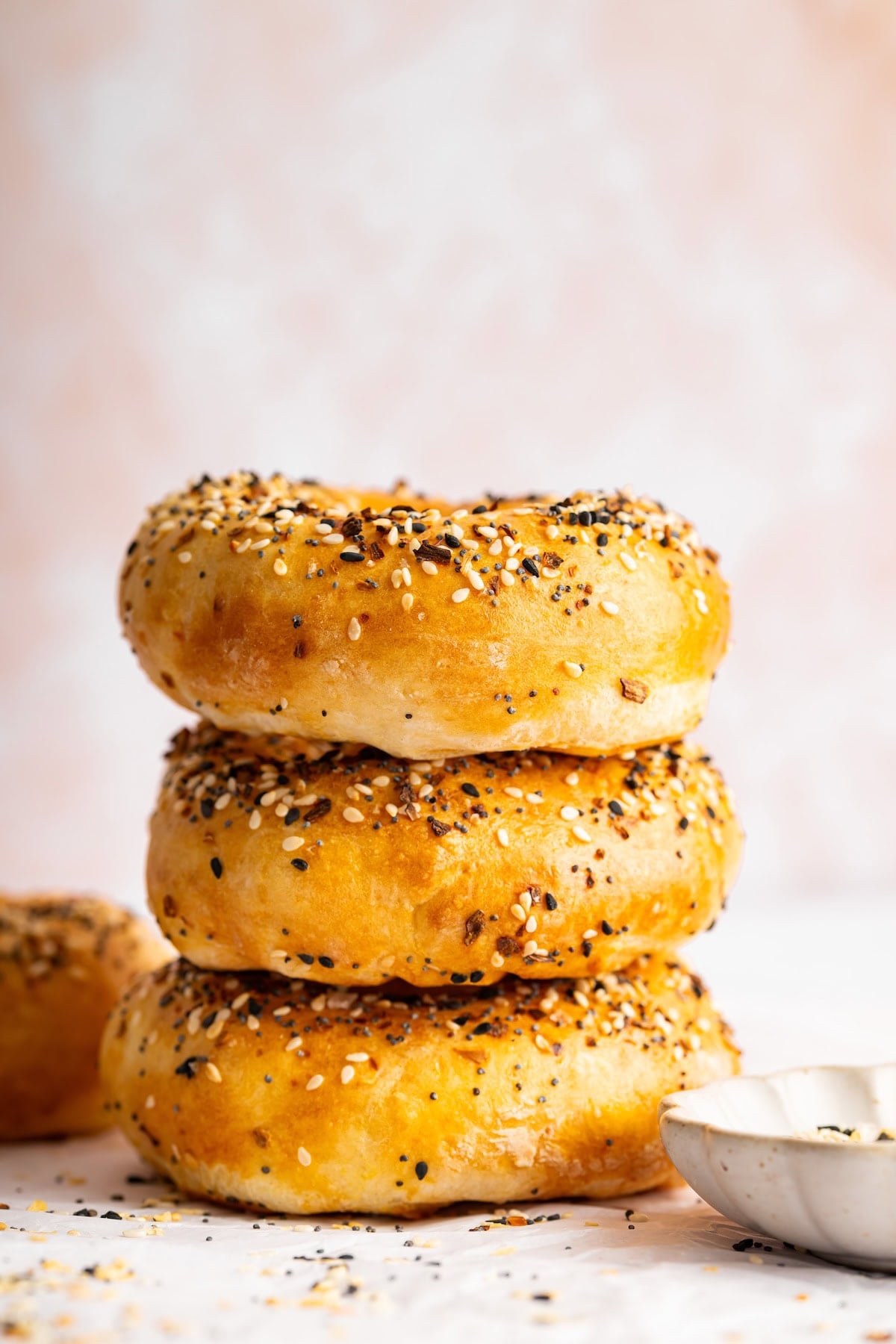 Stack of golden brown cottage cheese bagels topped with everything bagel seasoning.