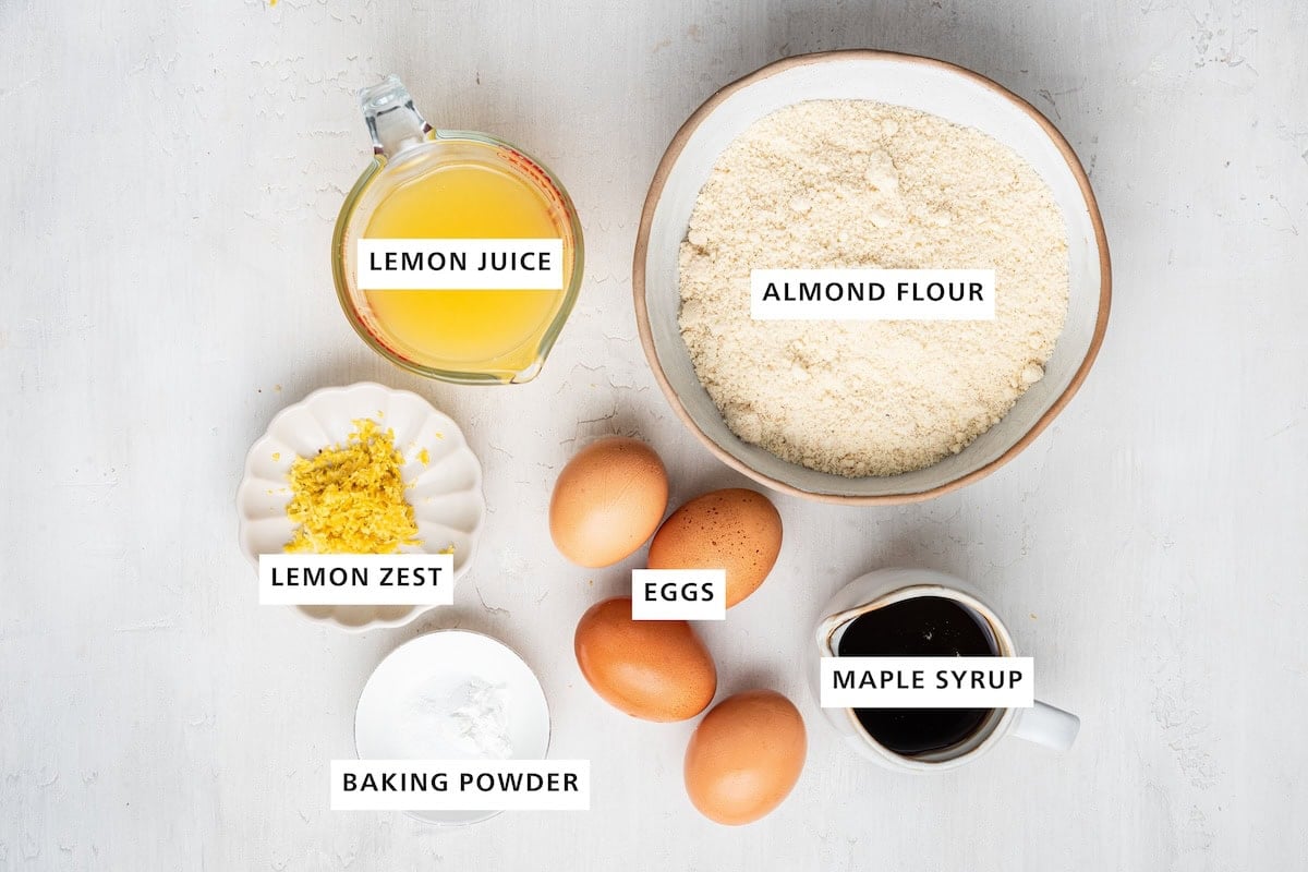Ingredients measured out to make Healthy Lemon Bars: almond flour, maple syrup, eggs, lemon juice, lemon zest and baking powder.