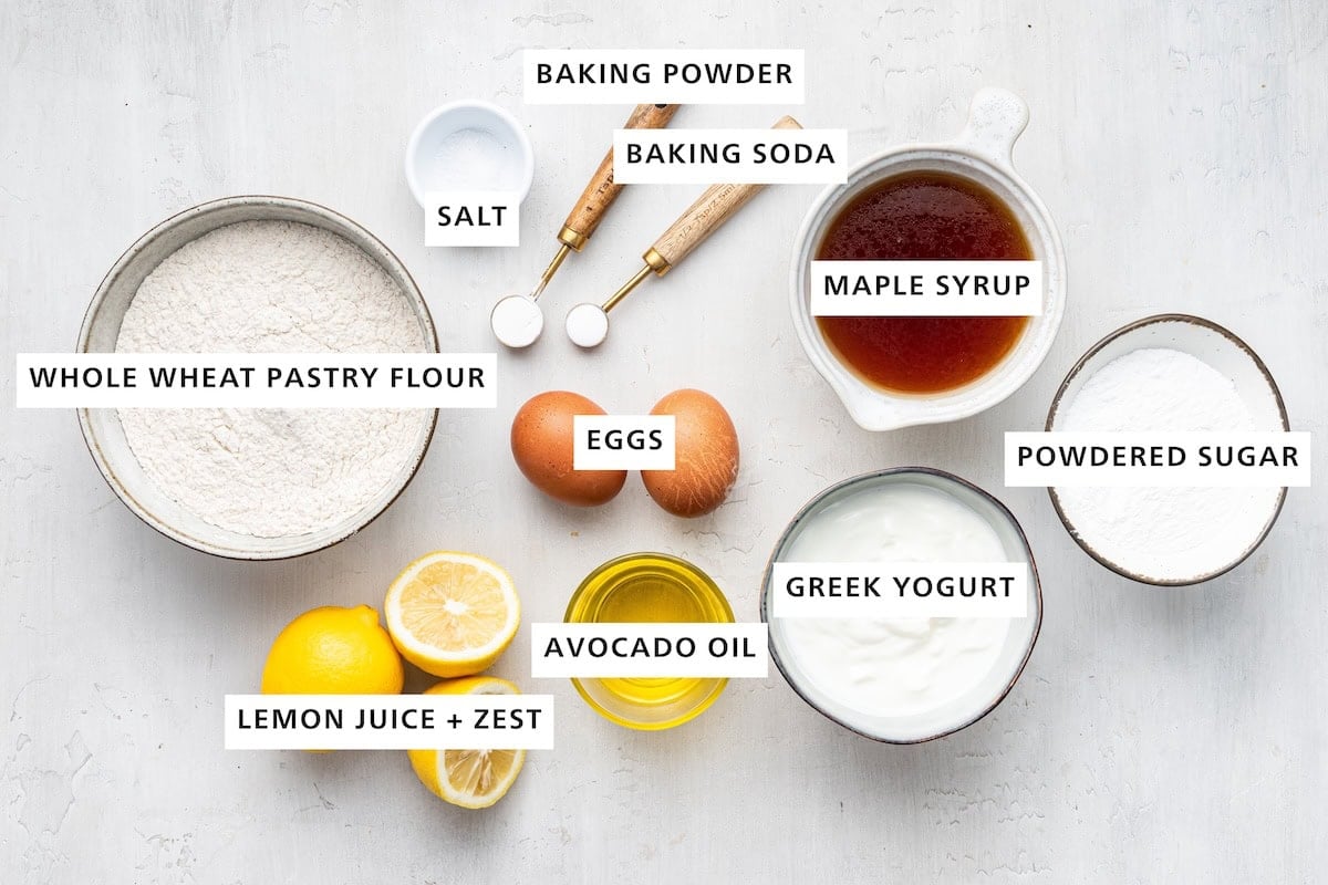 Ingredients measured out to make a lemon loaf: whole wheat pastry flour, lemon juice and zest, salt, avocado oil, eggs, baking powder, baking soda, Greek yogurt, maple syrup and powdered sugar.