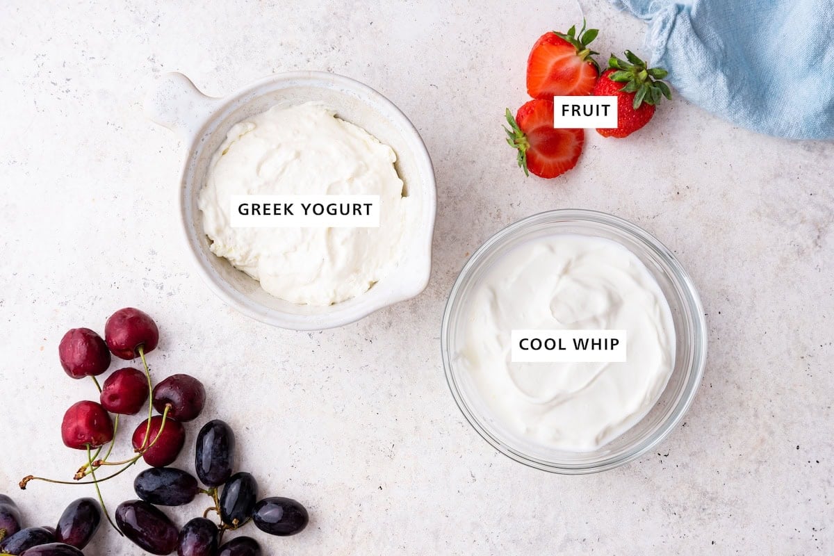 Ingredients measured out to make Yogurt Fruit Dip: greek yogurt, cool whip and fruit.