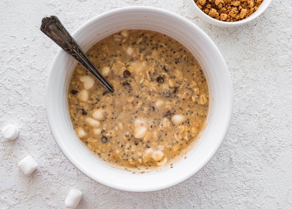 A large mixing bowl with ingredients soaking used for s'mores overnight oats.
