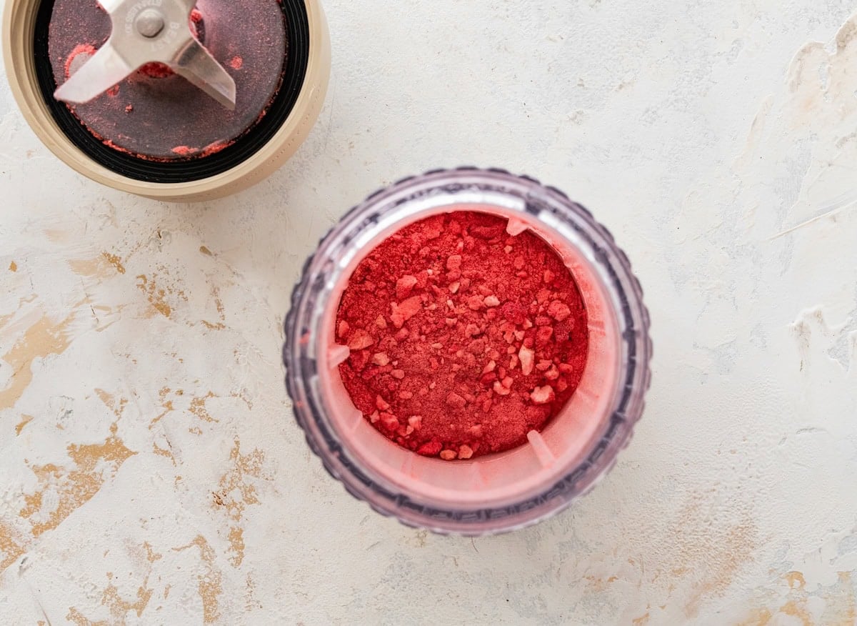 Blended freeze-dried strawberries in a food processor for strawberry protein balls recipe.