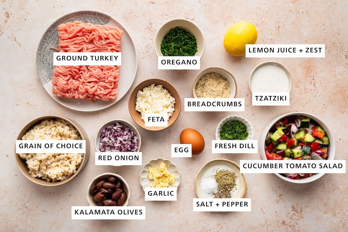 Ingredients measured for Greek turkey meatballs: Ground turkey, oregano, lemon juice, lemon zest, breadcrumbs, tzatziki, feta, brown rice, red onion, egg, fresh dill, cucumber tomato salad, garlic, kalamata olives, salt, and pepper.