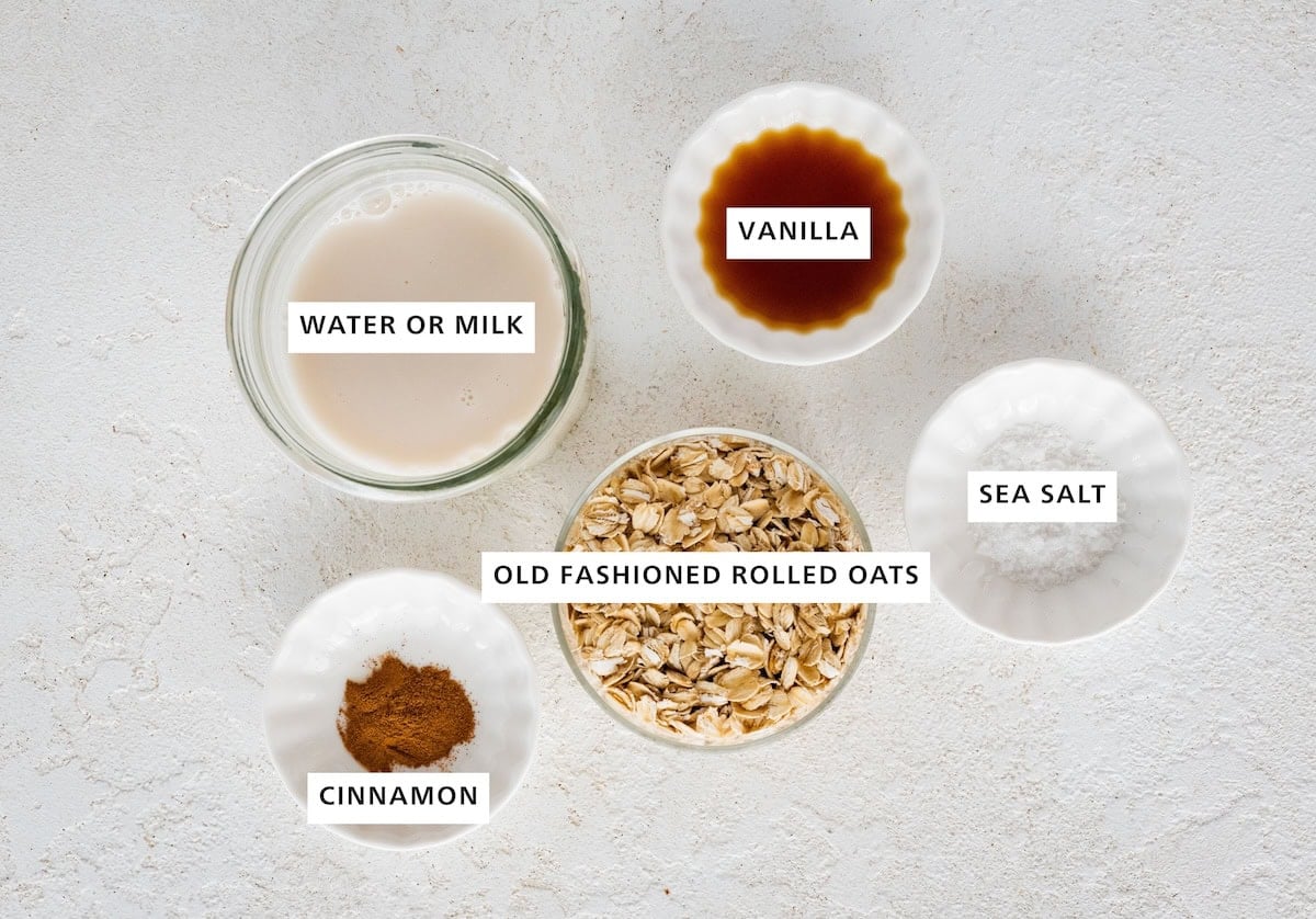 Ingredients measured out to make oatmeal: cinnamon, milk, oats, vanilla and sea salt.