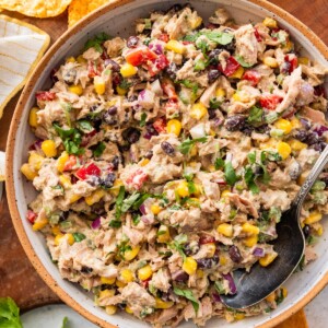 A large bowl of Mexican tuna salad with black beans, corn, fresh vegetables, and cilantro.