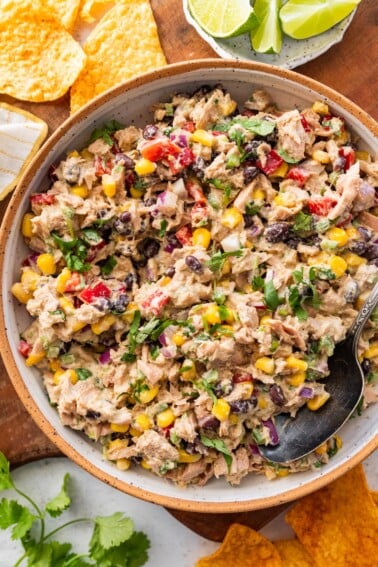 A large bowl of Mexican tuna salad with black beans, corn, fresh vegetables, and cilantro.