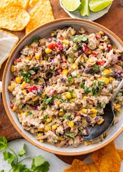A large bowl of Mexican tuna salad with black beans, corn, fresh vegetables, and cilantro.