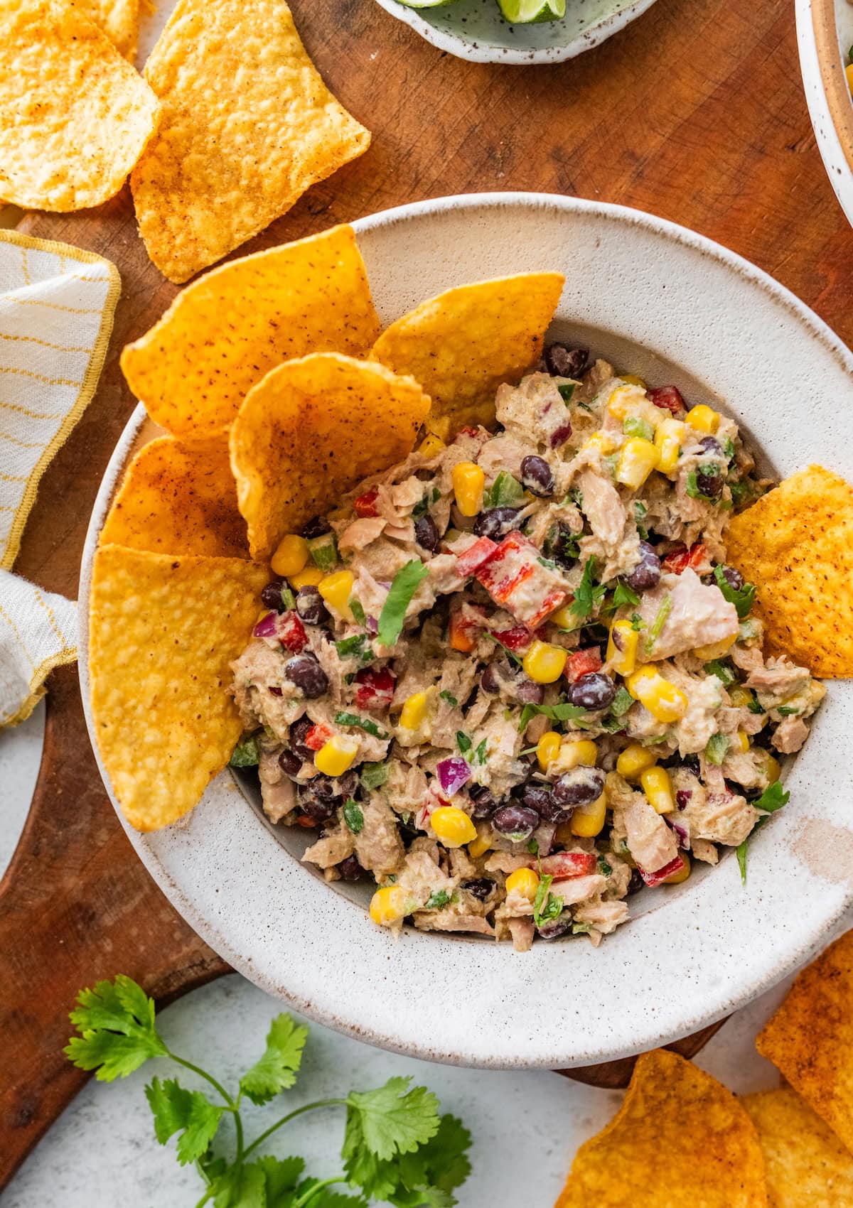 A serving of Mexican tuna salad in a bowl with tortilla chips on the side.