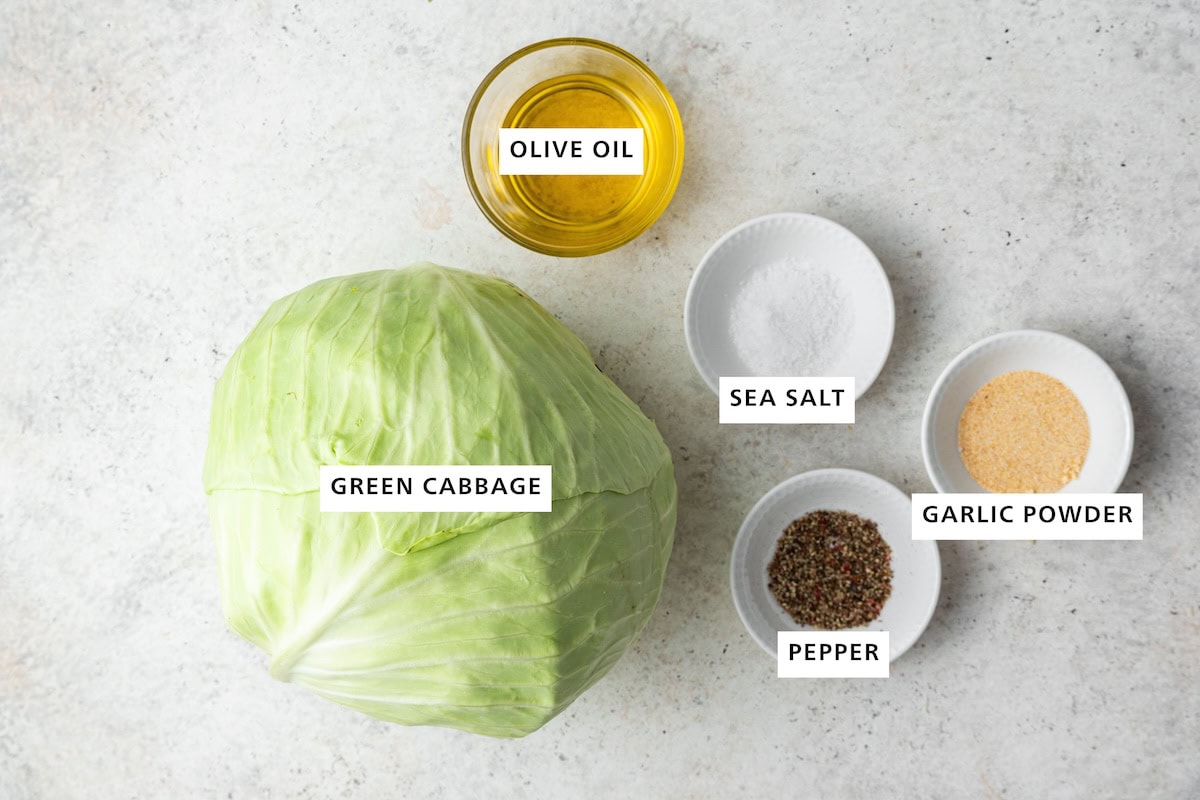 Ingredients measured out to make Roasted Cabbage: green cabbage, olive oil, pepper, sea salt and garlic.