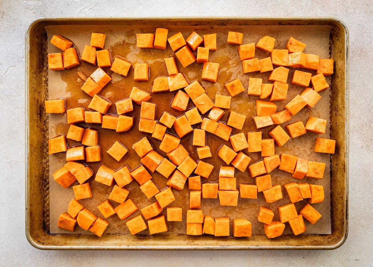 Cubed sweet potatoes on a baking tray before being roasted in the oven.