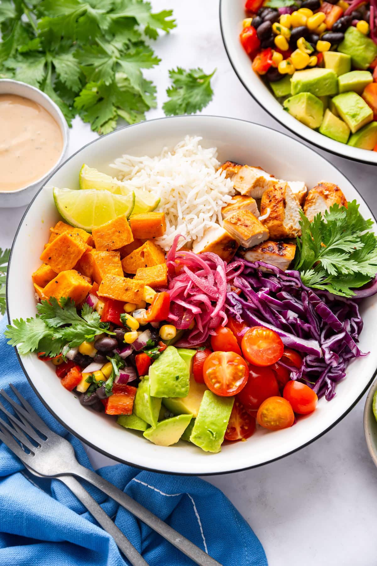 A serving of BBQ chicken bowl with fresh vegetables and white rice.