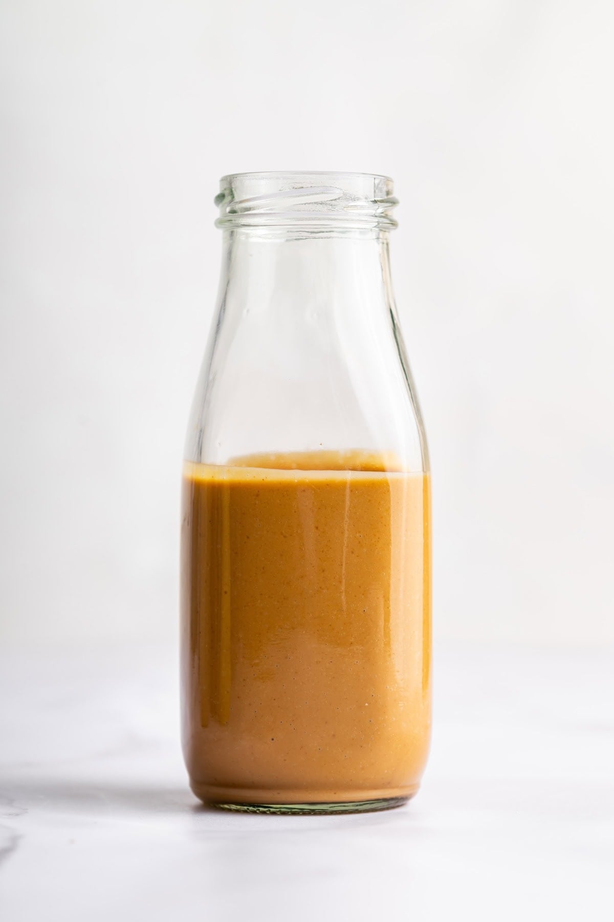 A peanut dressing in a glass bottle.