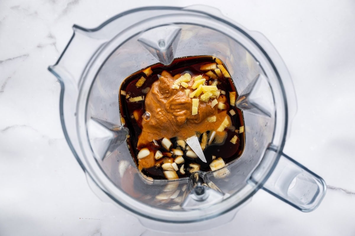 Ingredients for a peanut dressing in a blender before being blended.