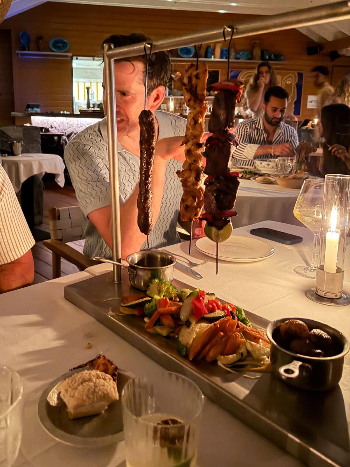 Meatballs served on a hanging skewer rack over a table spread at Sella restaurant in St. Barths