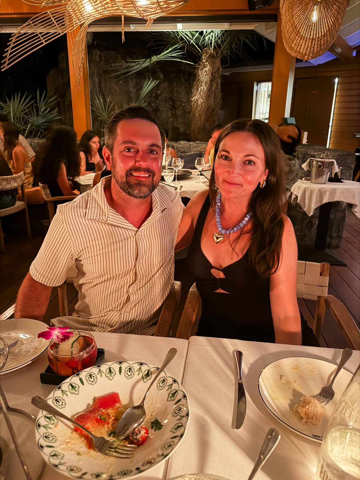Brittany and Isaac smiling over dinner at Bonito restaurant in St. Barths