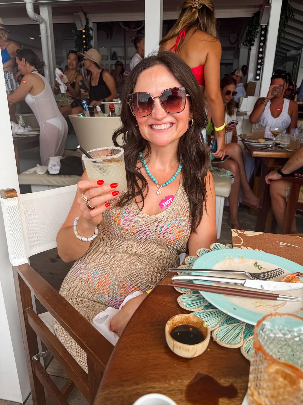 Brittany holding a cocktail and smiling at Nikki Beach in St. Barths