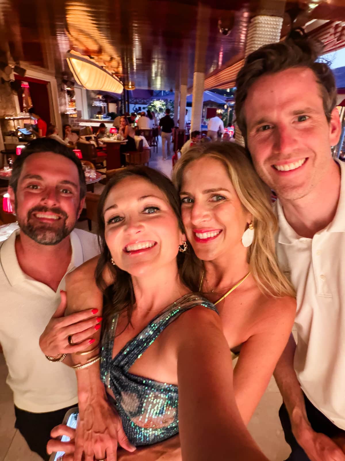 Group selfie of four friends at Sella restaurant in St. Barths