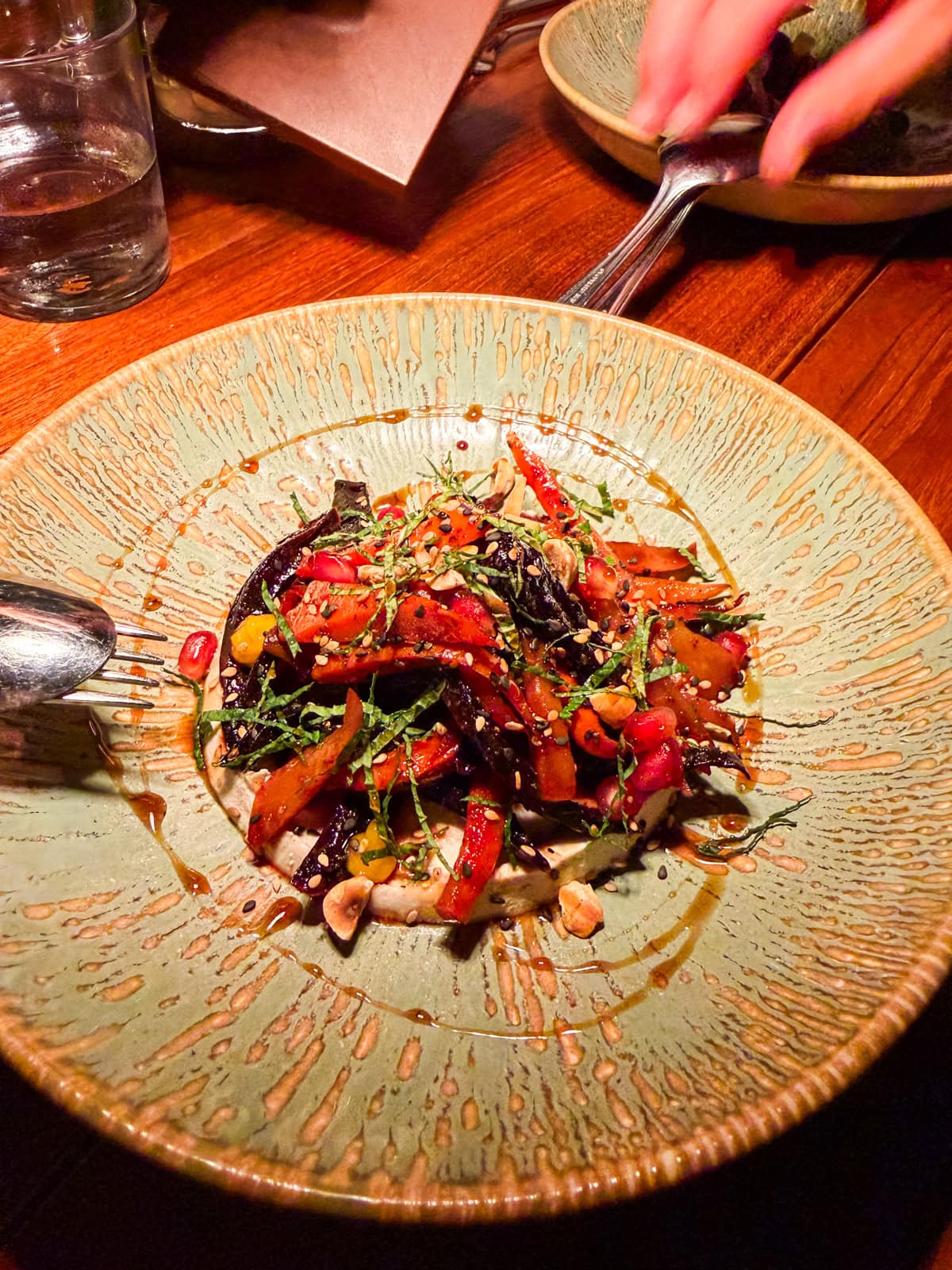 Roasted carrots with tahini and herbs on a teal plate at Tamarin restaurant in St. Barths