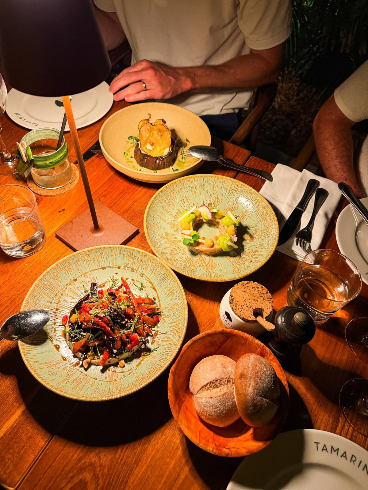 Aerial view of dinner at Tamarin restaurant with roasted vegetables, fish, and eggplant