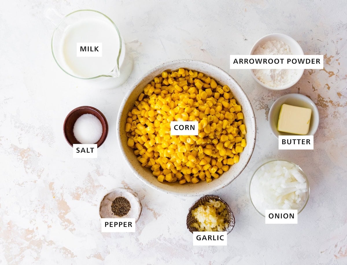 Ingredients measured out to make Creamed Corn: pepper, salt, milk, corn, garlic, onion, butter and arrowroot powder.