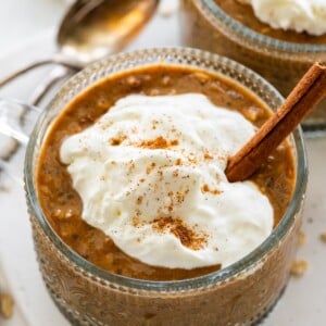 Pumpkin spice latte overnight oats in a glass topped with Greek yogurt and cinnamon.