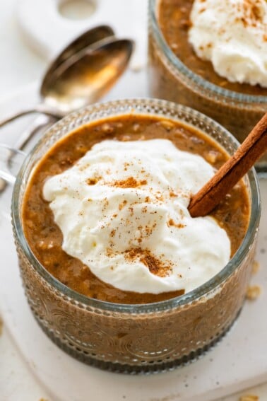Pumpkin spice latte overnight oats in a glass topped with Greek yogurt and cinnamon.