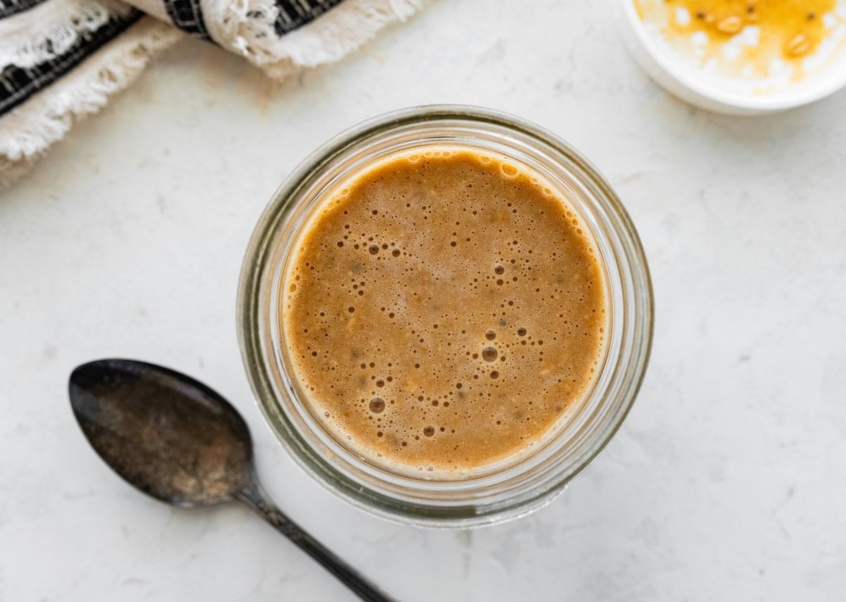 Pumpkin spice latte overnight oats soaking in a glass cup.