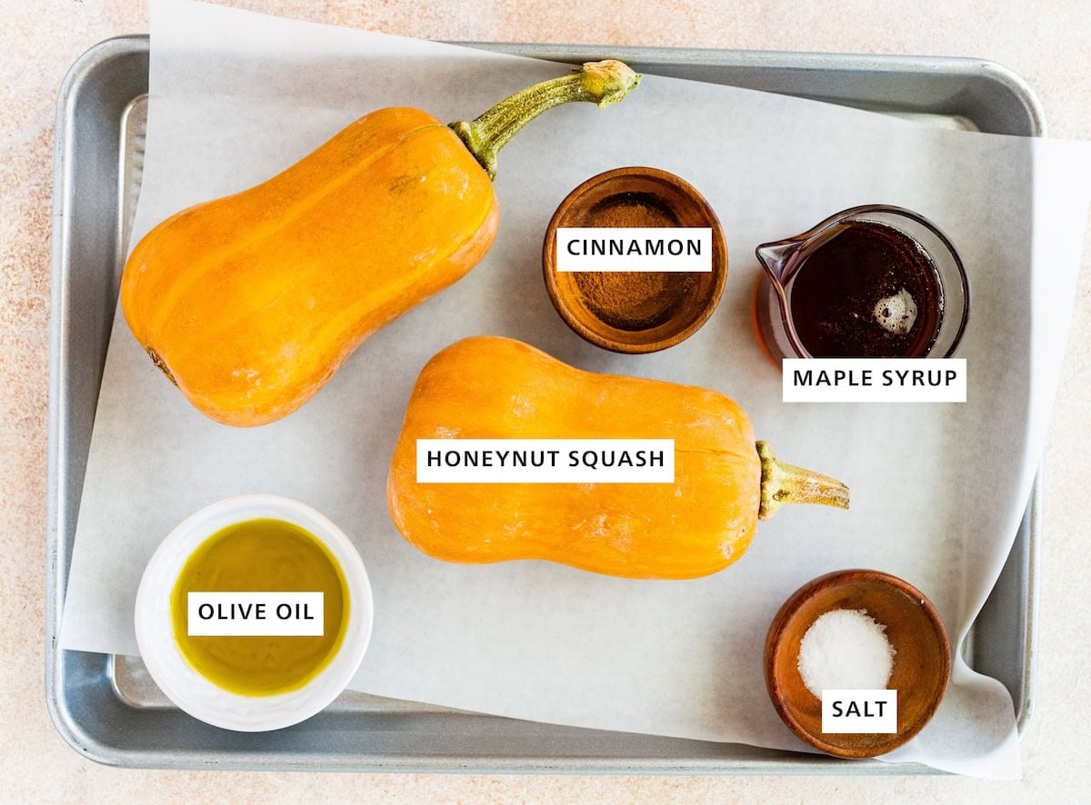 Ingredients measured out to make Roasted Honeynut Squash: maple syrup, sea salt, cinnamon, honeynut squashes and olive oil.