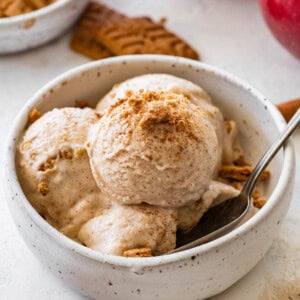 Apple pie ice cream served in a bowl topped with crushed graham crackers and a sprinkle of cinnamon.