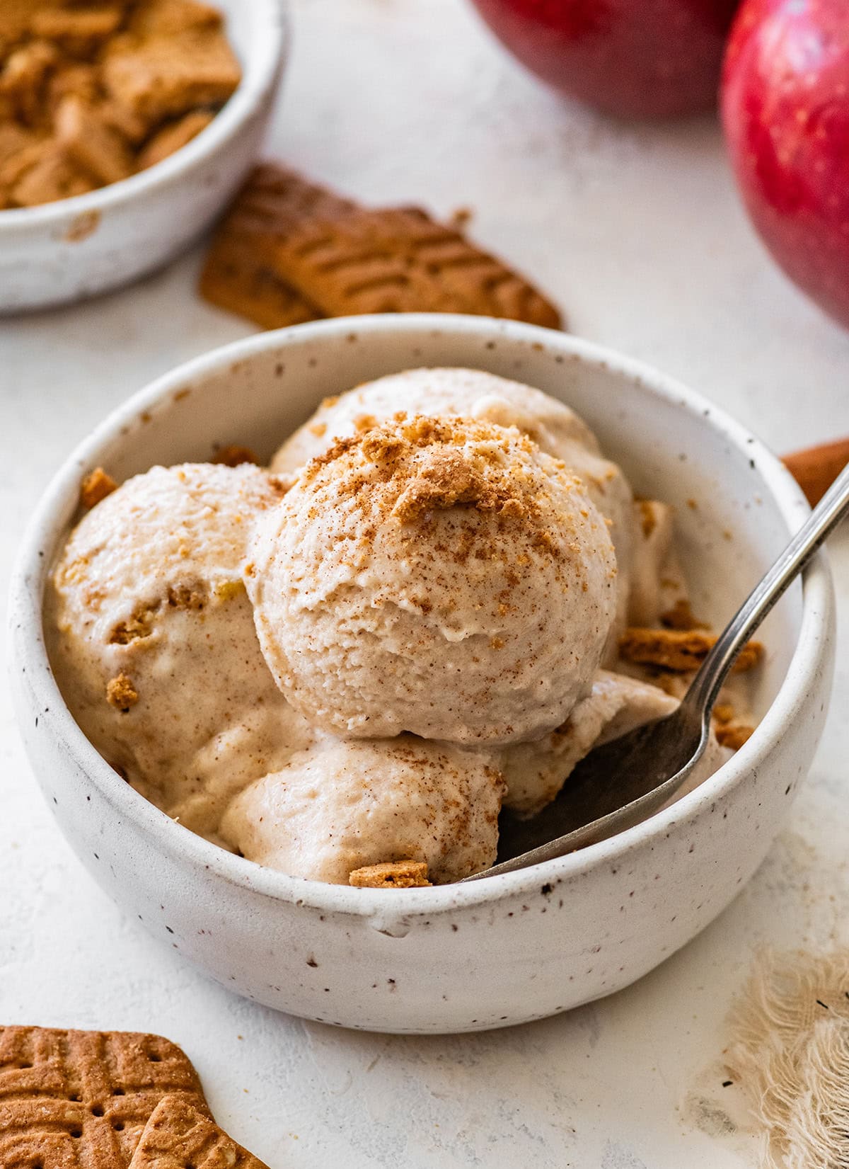 Apple pie ice cream served in a bowl topped with crushed graham crackers and a sprinkle of cinnamon.