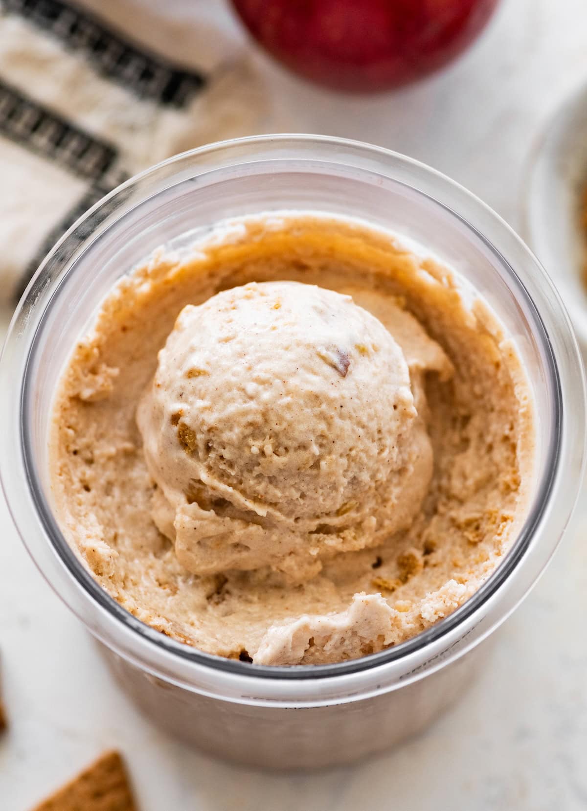 Apple pie ice cream in a Ninja Creami container with chunks of cinnamon apples and graham crackers.